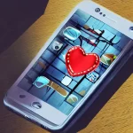 un smartphone sobre un escritorio con un corazon en su pantalla